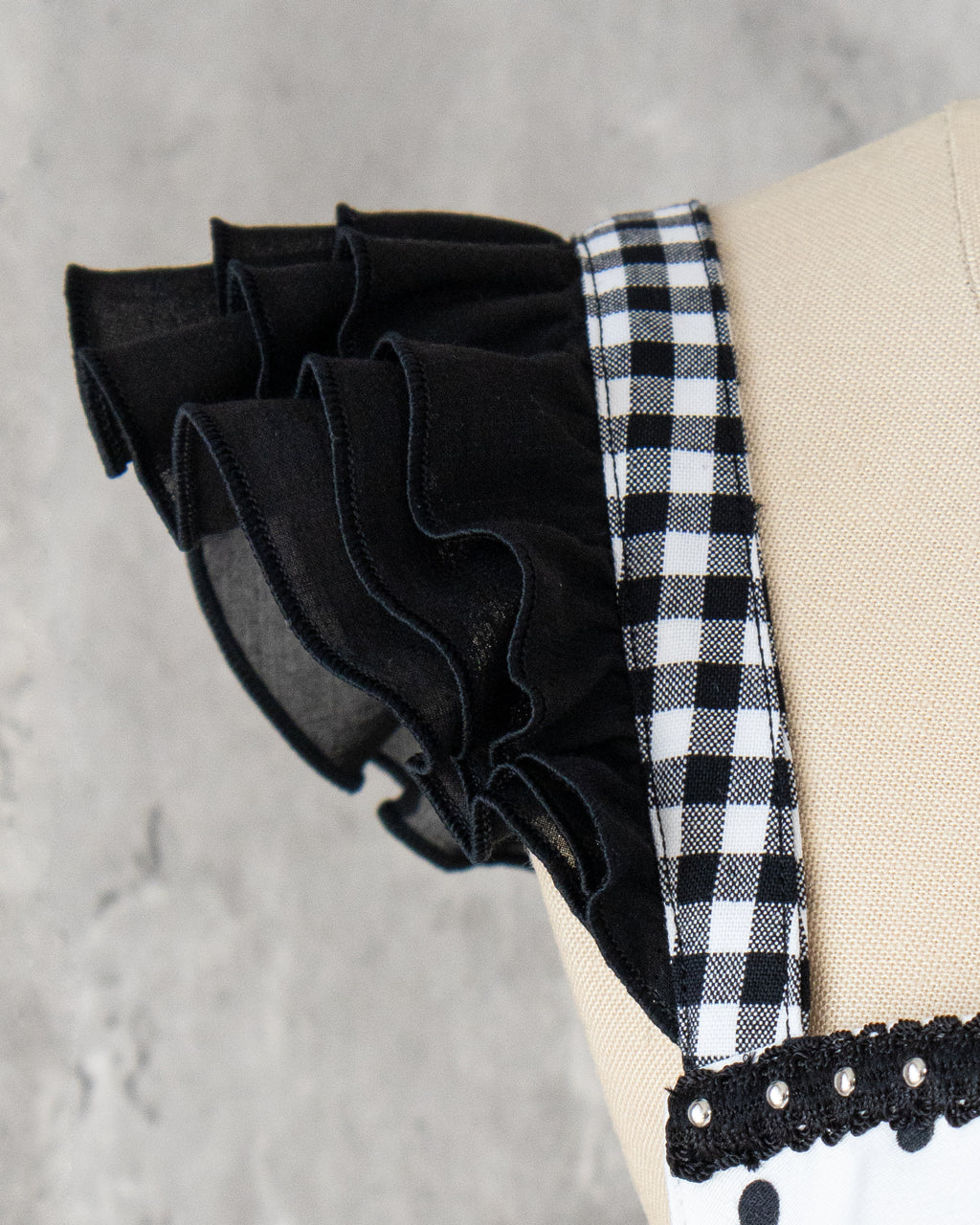 ショルダーストラップ部分のアップ。ギンガムのショルダーストラップに黒の３段フリル。