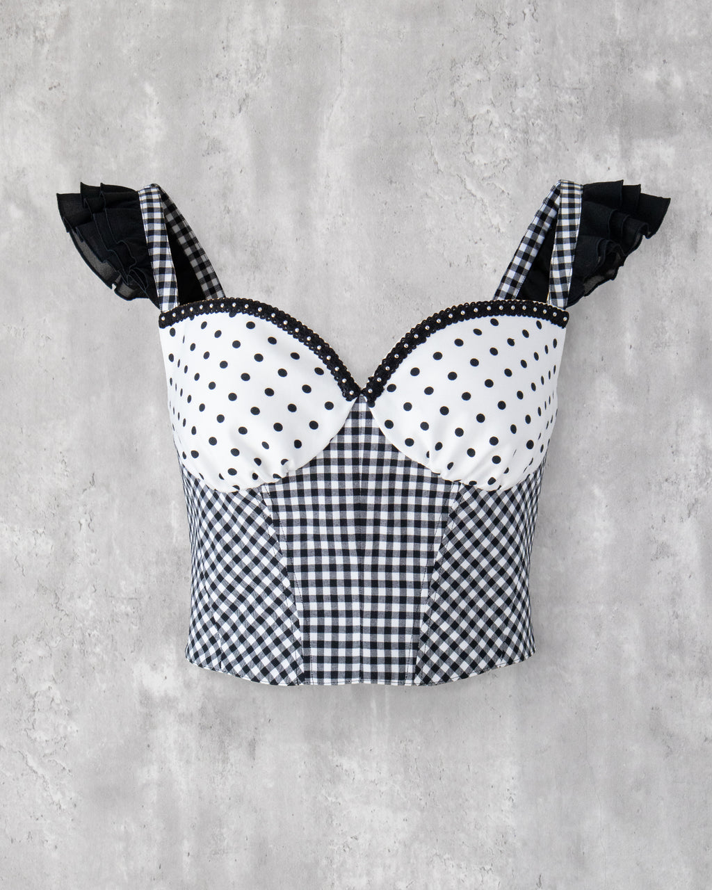 水玉とギンガム柄を組み合わせたビスチェ。肩に黒のフリル、胸元にはスタッズブレードのアクセント。
