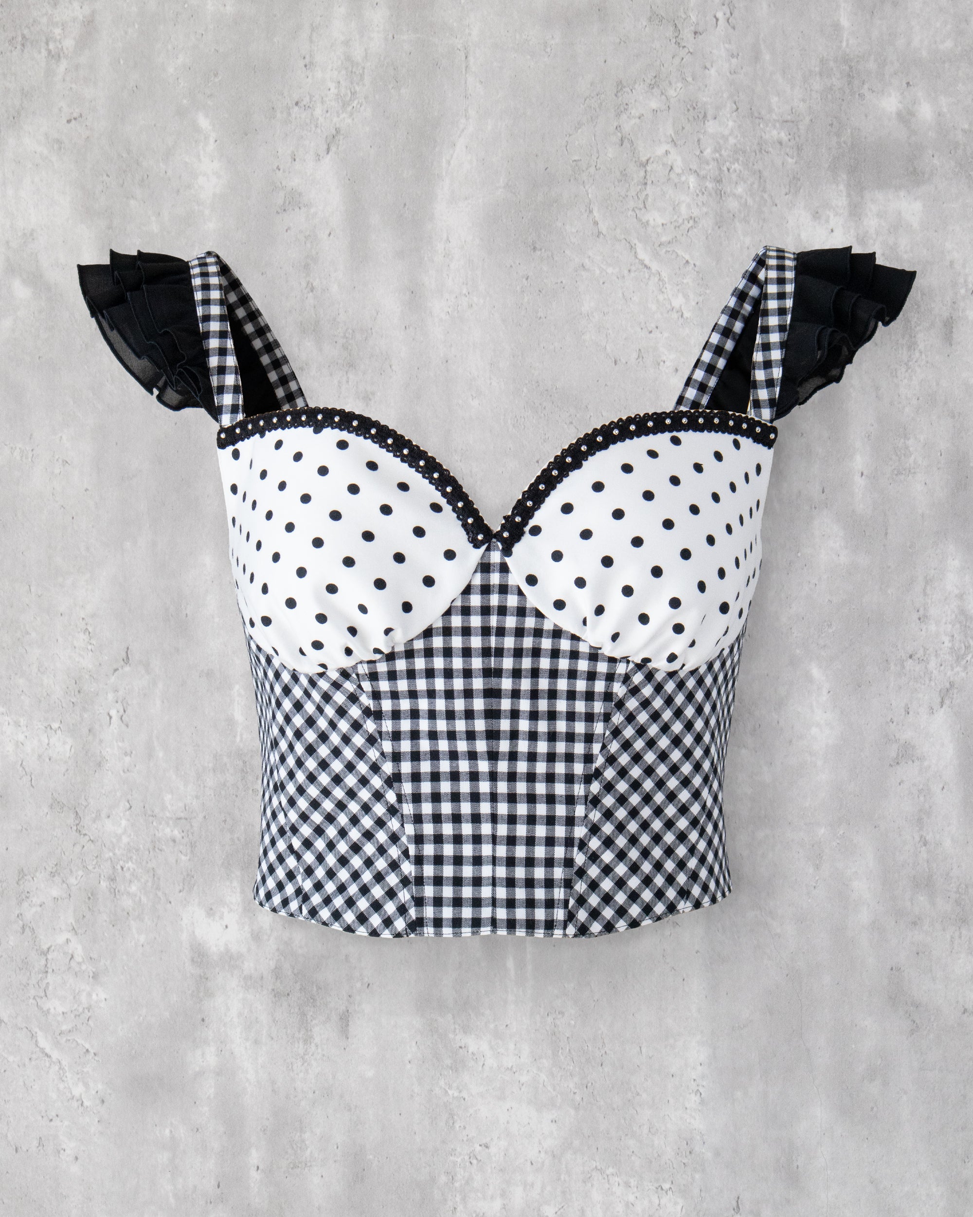 水玉とギンガム柄を組み合わせたビスチェ。肩に黒のフリル、胸元にはスタッズブレードのアクセント。