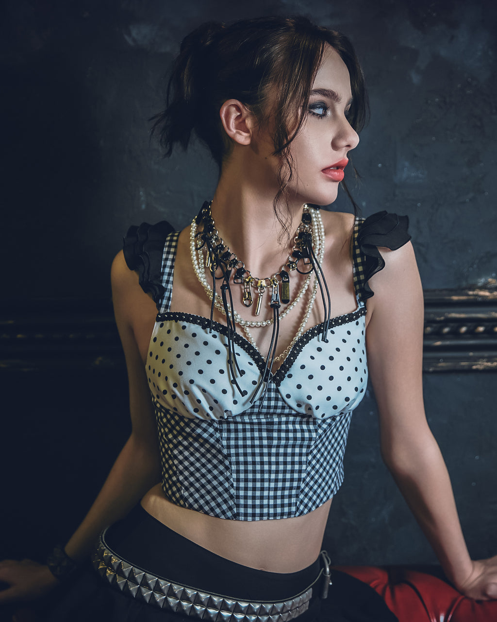 水玉とギンガム柄のビスチェに黒のスカートを着用したモデル写真。スタッズベルトや、エッジィなアクセサリーで、パンクなスタイリング。