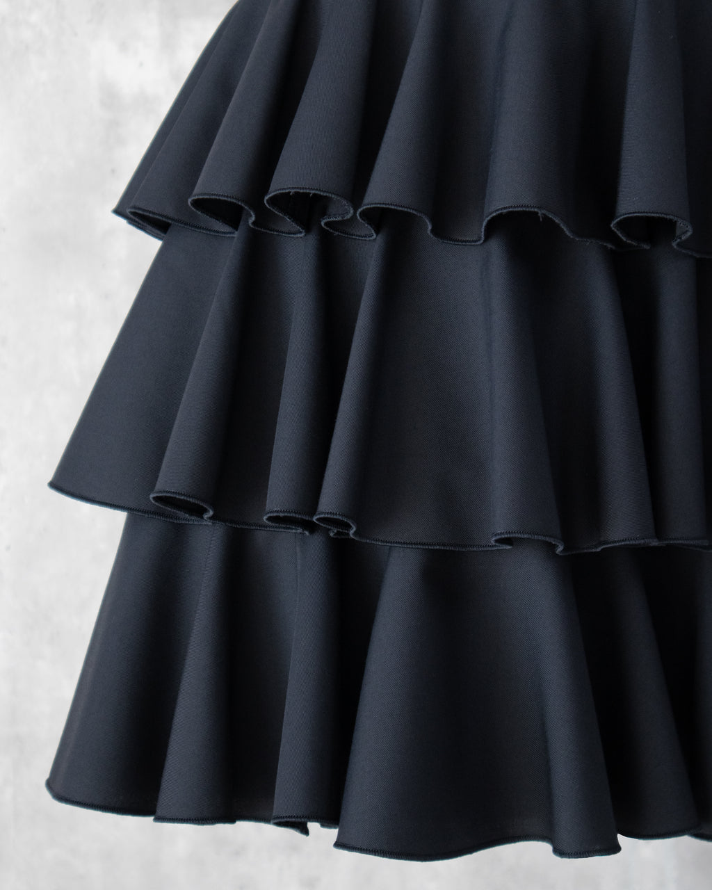 黒の３段ティアードフリルスカートのフリルのアップ。上品な光沢に肌触りの良い生地。