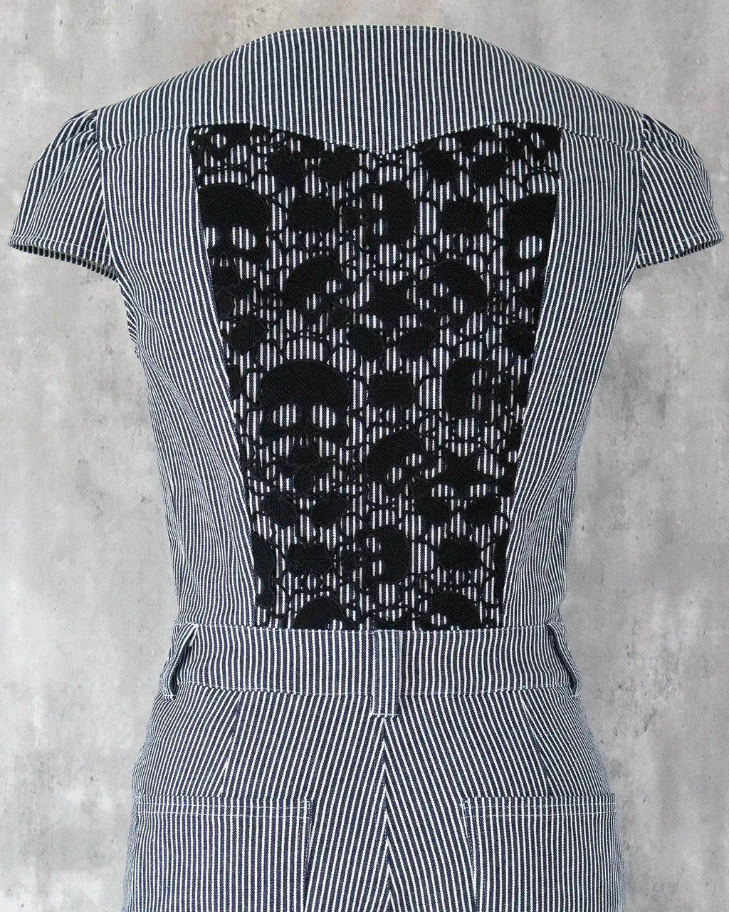 White skull lace detail on indigo hickory denim — Carla Jumpsuit by Atë, back panel close-up