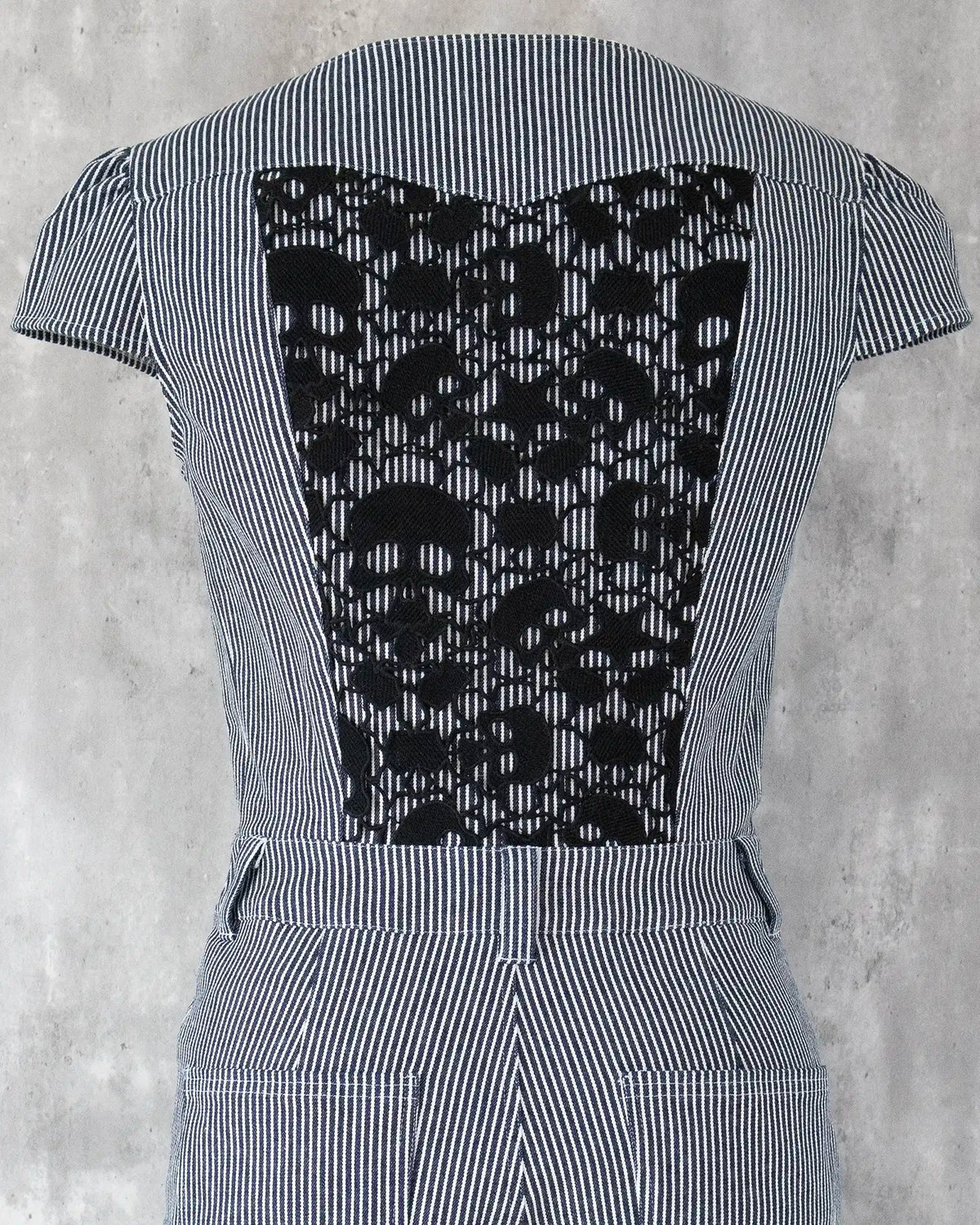White skull lace detail on indigo hickory denim — Carla Jumpsuit by Atë, back panel close-up
