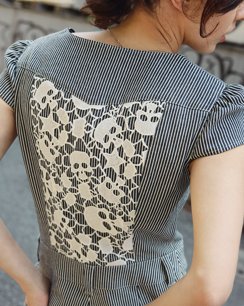 Skull lace back panel detail on a women's hickory stripe denim jumpsuit, made in Japan — Carla Jumpsuit by Atë