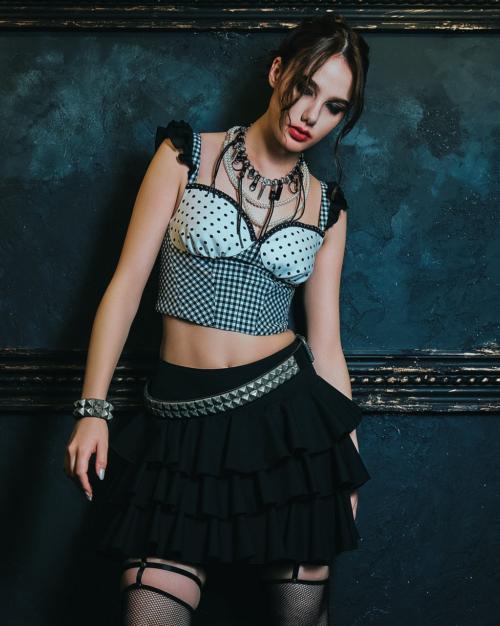 黒の３段ティアードフリルスカートと、水玉・ギンガム柄を組み合わせたビスチェを着たモデル写真。スタッズベルトや、エッジィなアクセサリーとのスタイリングでパンクに。